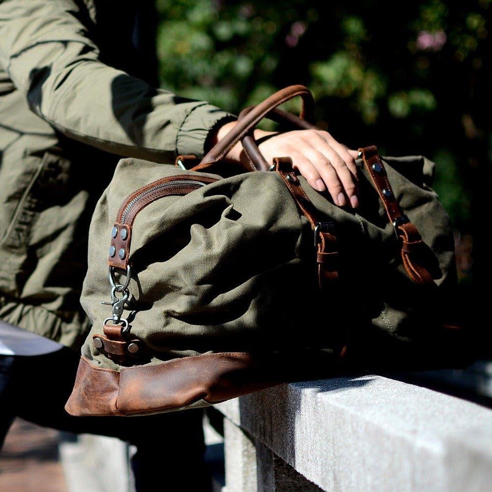 holding a Woosir waxed canvas weekender bag