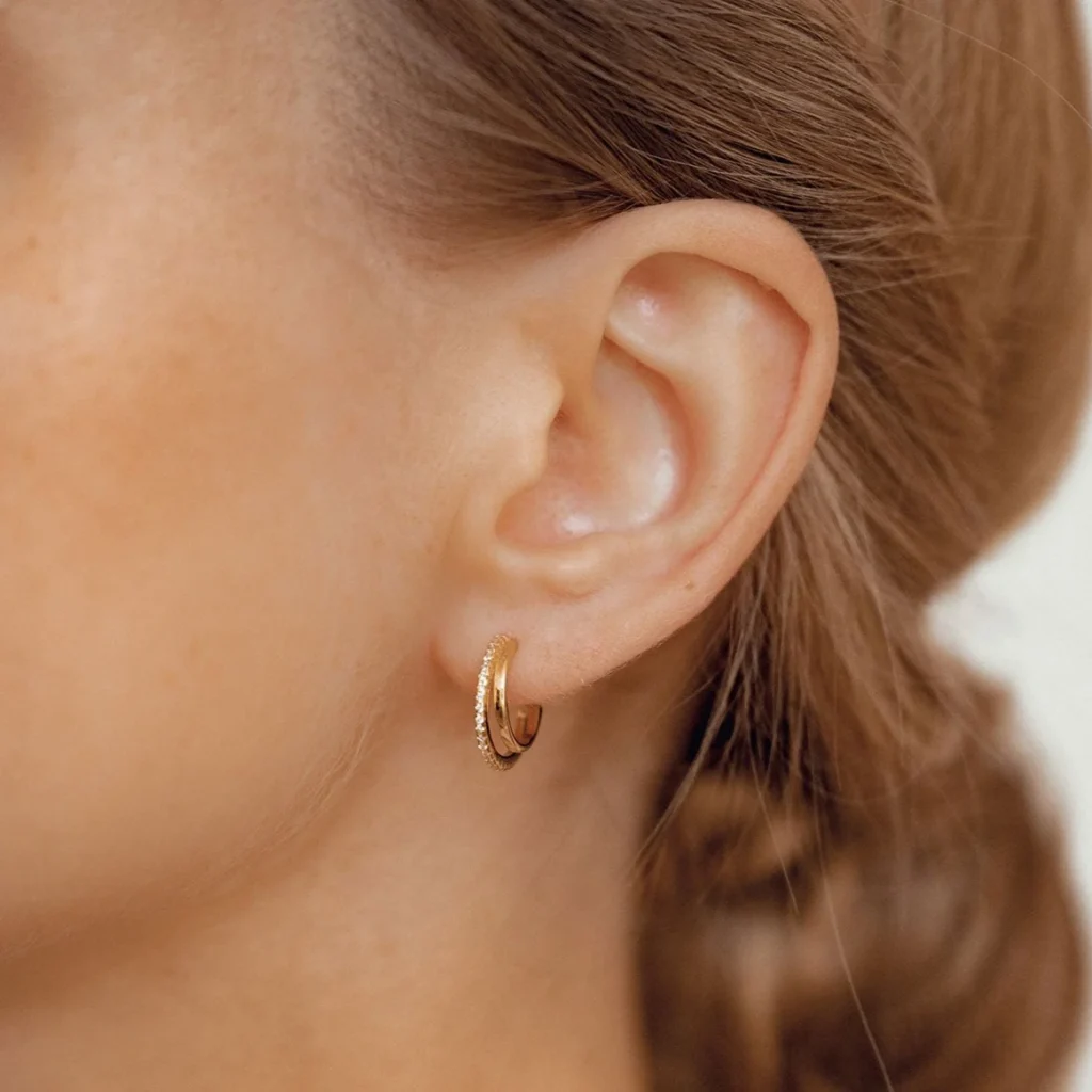 Close-up of gold hoop earrings worn on an ear